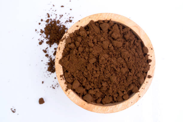 istock Coffee grounds in a wooden bowl isolated on white background. 1473849994