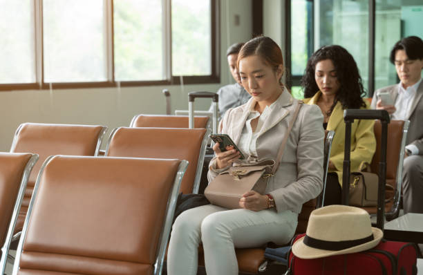 istock Passengers waiting for their flight in airport terminal and using mobile phone 1473851674