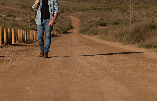 Adult man walking on dirt road