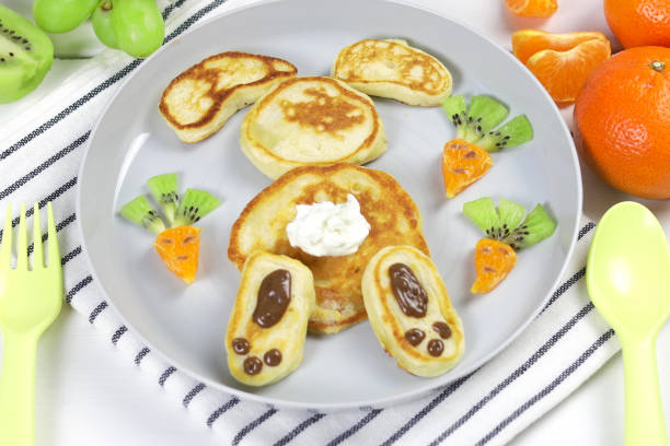 Funny food idea for kids. Children's breakfast: pancakes in the form of a funny rabbit with cottage cheese and chocolate paste. Funny food idea for kids. Children's breakfast: pancakes in the form of a funny rabbit with cottage cheese and chocolate paste. bunny pancake stock pictures, royalty-free photos & images