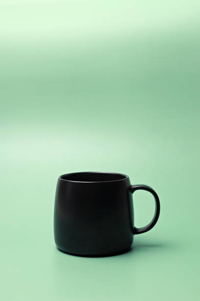 istock Black coffee or tea cup on green background 1473856539