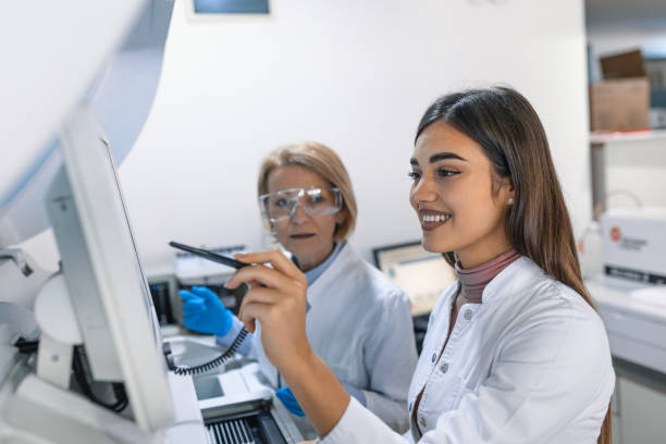 istock Two Research Scientists Programm Medical Equipment with Tablet Computer. Team of Professionals Doing Pharmaceutical Research in Modern Laboratory. 1473856638