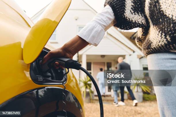 Woman Plugging Electric Charger Into Car Stock Photo - Download Image Now - Electric Vehicle, Charging, Electric Car