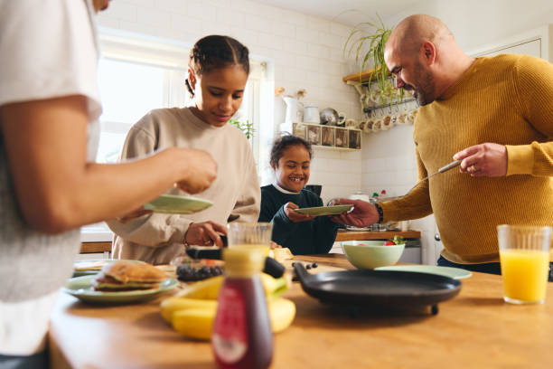 Family and boy with Down syndrome serving pancakes for breakfast