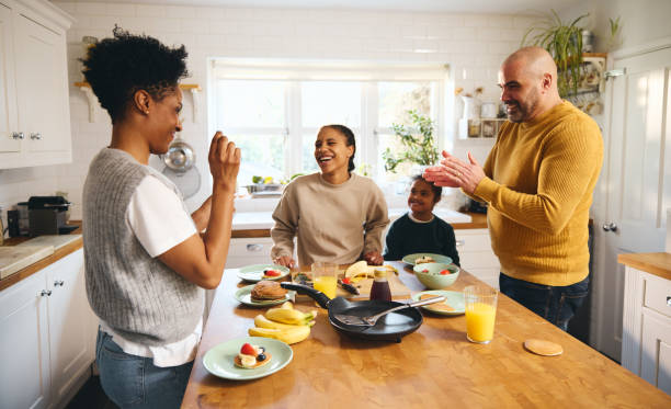 istock Boy with Down syndrome having pancakes for breakfast with parents 1473857518