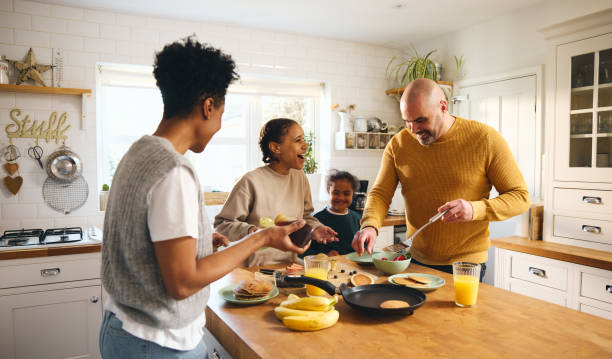 Family and boy with Down syndrome making pancakes for breakfast