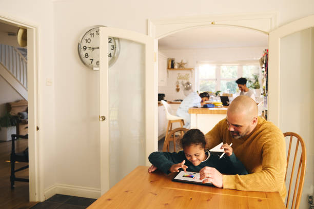 istock Multiracial father and son with Down syndrome using digital tablet 1473857525
