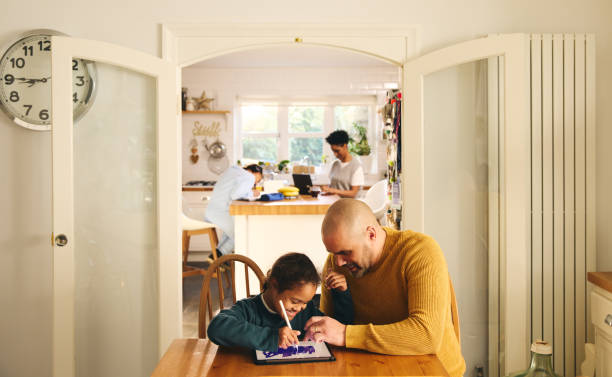 istock Multiracial family at home with father and son with Down syndrome using digital tablet 1473857528