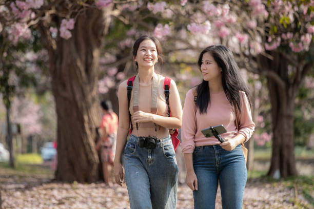 istock Two female tourists walking happily chatting. 1473858073