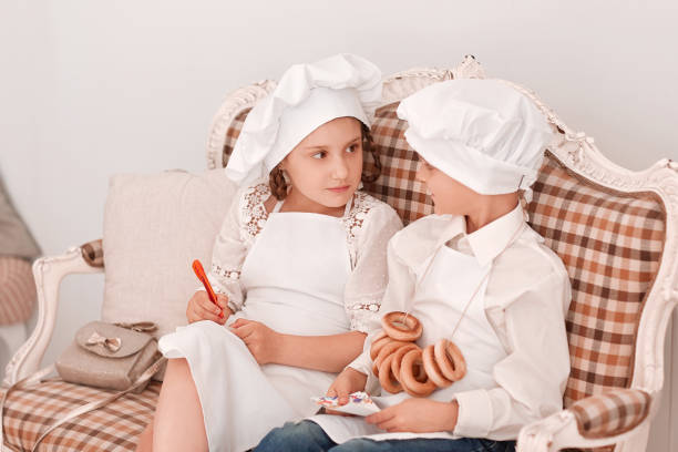 brother and sister in chef's caps discuss the lunch menu.Hobbies and interests