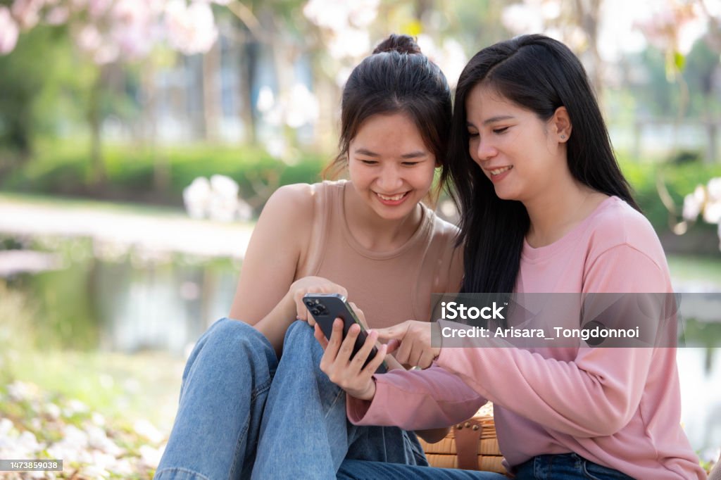 lgbtq couple watching something on their phones and laughing happily 18-19 Years Stock Photo