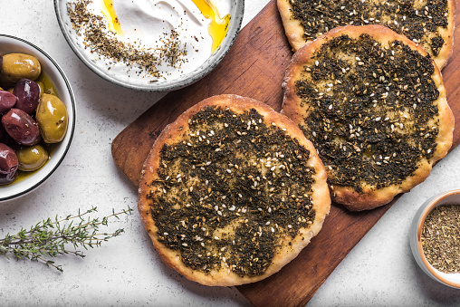 Manakeesh, arabic pizza, flat bread topped with zaatar spices close up. Homemade  mediterranean flat bread manakish for breakfast.