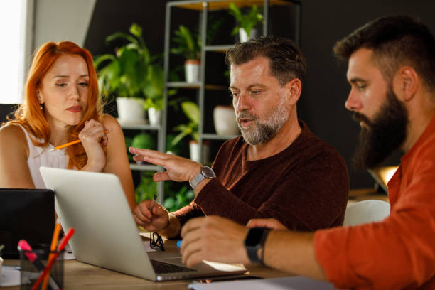 istock Business colleagues reviewing project documents and engaging in casual discussions 1473861102