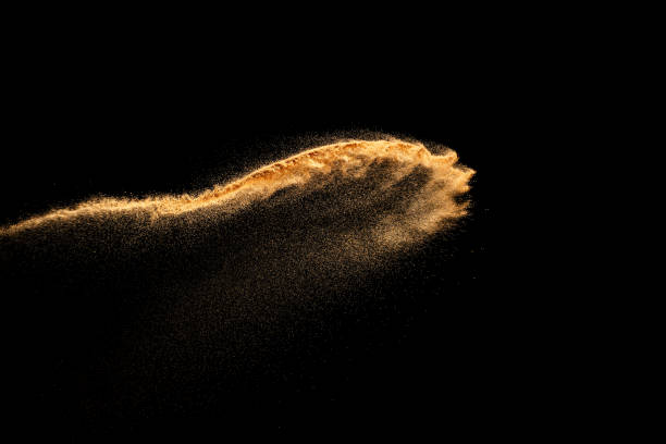 istock Dry river sand explosion. Brown color sand splash against black background. Yellow sand fly wave in the air. 1473861702