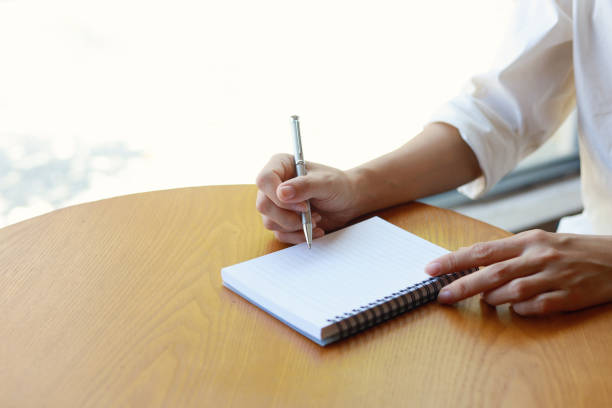 istock Woman sitting in her living room writing diary 1473862883
