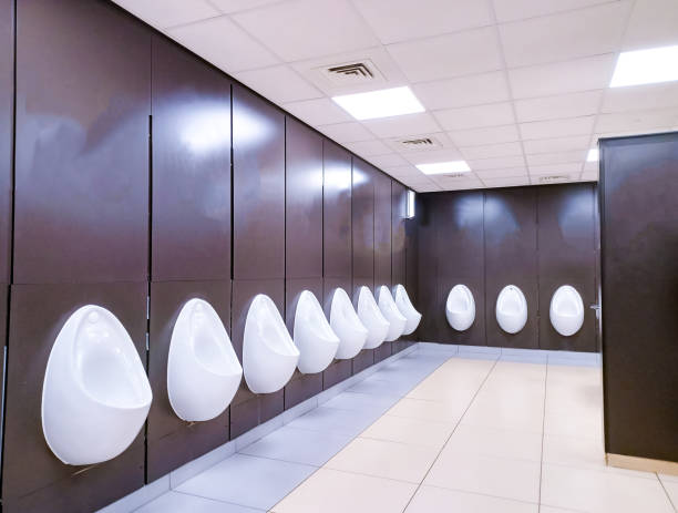 Male Toilet Urinals A row of several urinal toilets situated in a service station facilities. mens room stock pictures, royalty-free photos & images