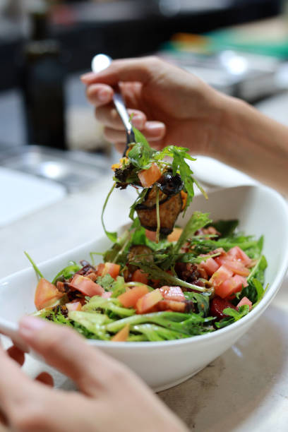 cropped shot of a woman's hand serving healthy salad in a restaurant. - gourmet enjoyment food freshness imagens e fotografias de stock