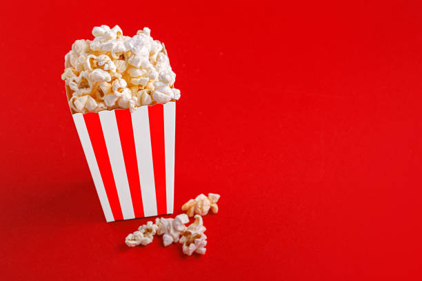 istock Glass with popcorn on a red background 1473870275