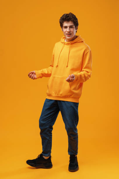 istock Young cheerful man dancing having fun over yellow background 1473870311