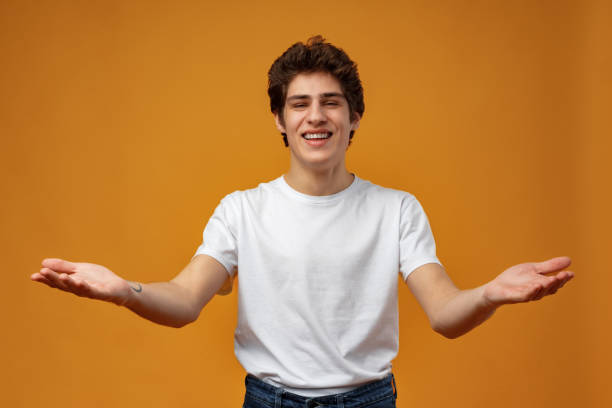 istock Young man standing over yellow background clueless and confused with open arms 1473872743