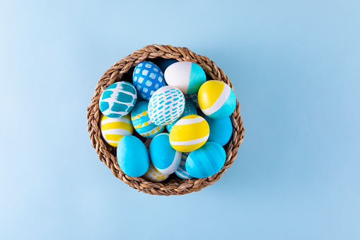 Easter eggs in a basket on blue background