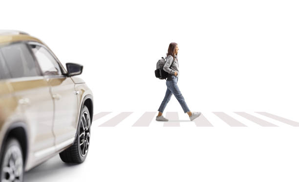 istock Female student with a backpack walking at a pedestrian crossing and SUV waiting 1473878222
