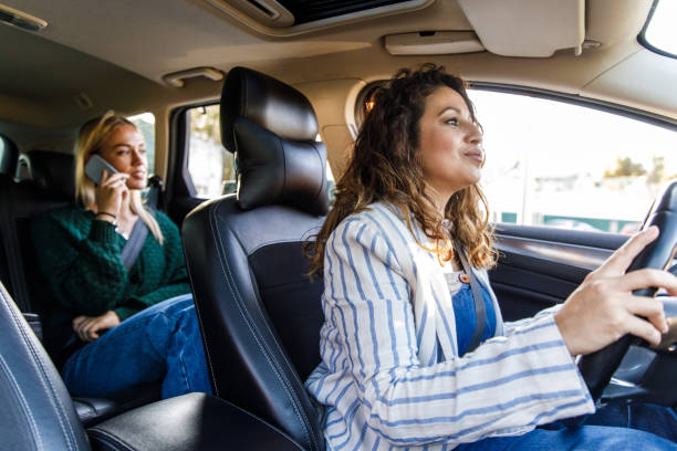 Female taxi driver taking the customer to her location stock photo