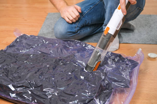 istock A man removes air from a vacuum bag using a manual vacuum cleaner. 1473880597