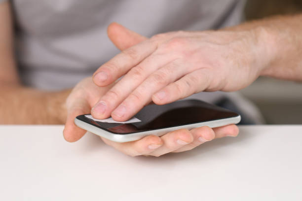 istock man cleans phone screen stick protective tempered glass. Broken glass 1473880602