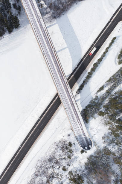 istock Truck on a winter road at a railway bridge 1473881048