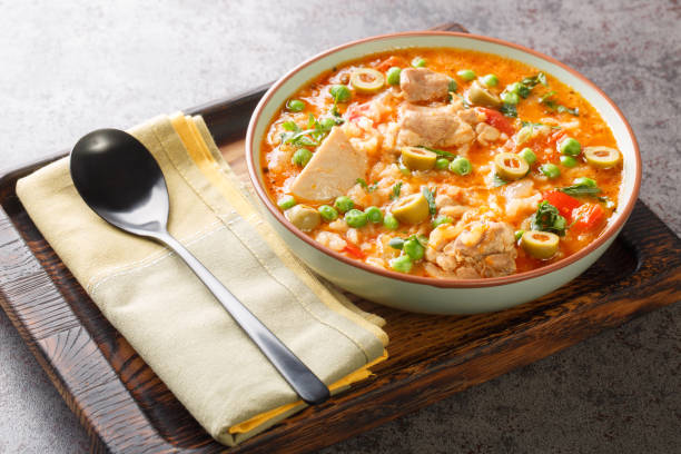 istock Asopao de pollo is a Caribbean dish that consists of sofrito, rice, tomato paste, and bite sized pieces of chicken closeup on the bowl. Horizontal 1473884120