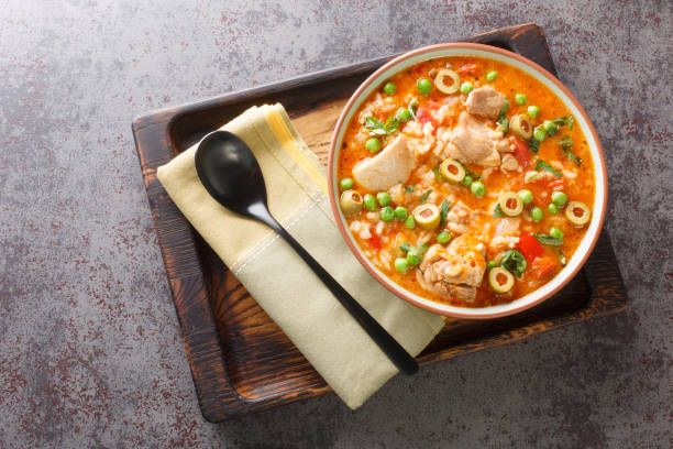 istock Asopao de pollo is a Caribbean dish that consists of sofrito, rice, tomato paste, and bite sized pieces of chicken closeup on the bowl. Horizontal top view 1473884339
