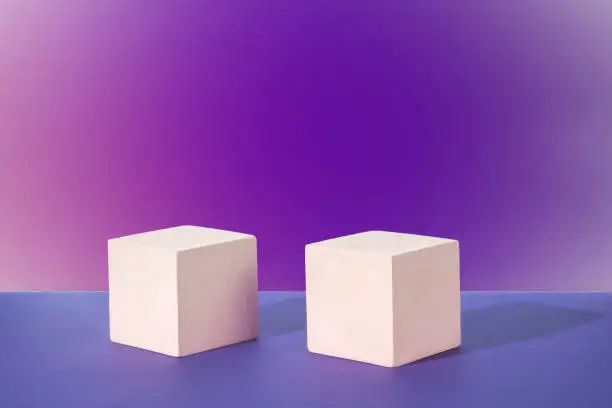 Cosmetic gradient purple-lilac background with geometric shapes. Two white cubic podiums. Mockup for the demonstration of cosmetic products.