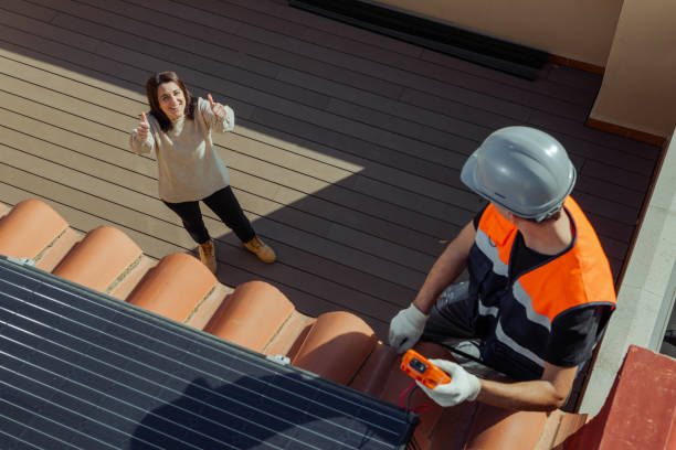 istock Happy house owner while worker installs solar panels for Alternative energy 1473884837