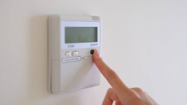 istock Female finger pressing air conditioner button on wall closeup 1473889148