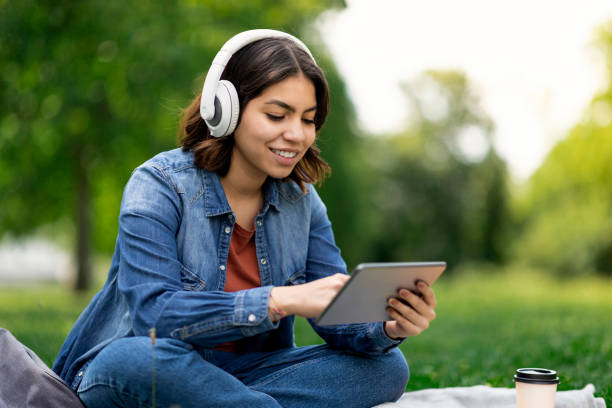 istock Young Middle Eastern Woman In Wireless Headphones Relaxing Outdoors With Digital Tablet 1473893105