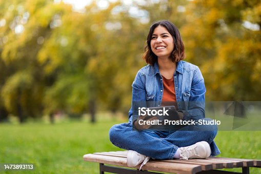 istock Happy Beautiful Young Arab Woman Relaxing With Digital Tablet Outdoors 1473893113