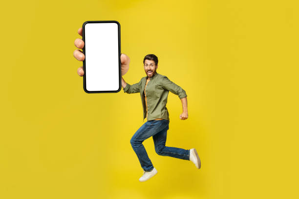 istock Smartphone with blank screen in jumping happy middle aged man hand, showing mobile application, mockup 1473893215