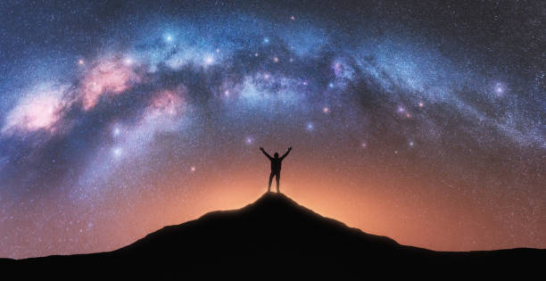 milky way and happy man with backpack on mountain peak at night - milky way galaxy space star imagens e fotografias de stock