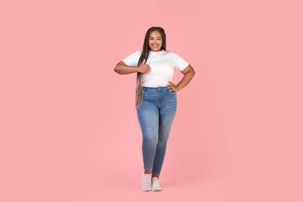 istock Cheerful Black Oversized Woman Gesturing Thumbs Up Over Pink Background 1473893956