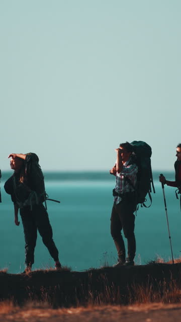 The four friends hiking on the sea shore background