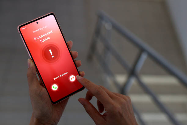 istock A woman receiving suspected spam call on smartphone from an unknown caller while walking down a staircase in an office. 1473896094