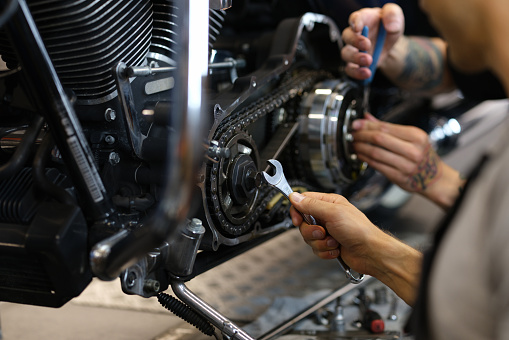 Maintenance of motorcycle engine clutch system by technicians. Repair and diagnostics of motorcycle engine breakdown concept