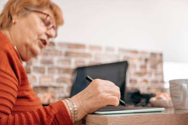istock Enjoying retirement by drawing with a graphic tablet 1473898741