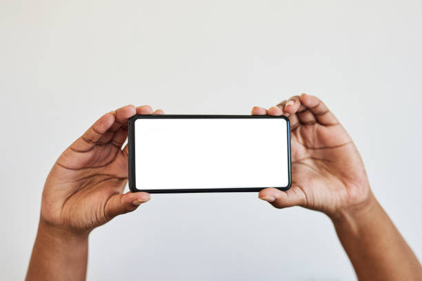 istock Hands, blank phone screen and mockup, black woman hand in studio isolated on white background. Technology, connect and zoom on space on smartphone for website, social media or product advertising. 1473899248