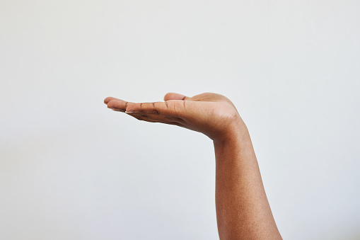 Woman, hand and closeup of holding gesture, offer or question, body language and symbol on white background. Open palm, hands ad girl asking, suggest or showing product placement space while isolated