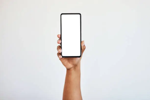 Photo of Hand holding phone, blank screen with mockup and black woman hands in studio isolated on white background. Technology, connect and zoom on space on smartphone for website, social media or advertising