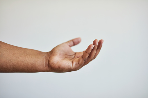 Open, giving and isolated hand in studio for product placement, receiving and promotion on white background. Charity, reaching out and person with palm up with copy space, begging and help gesture