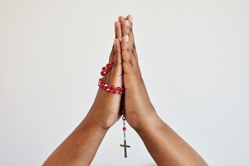 Hands, person praying and rosary beads with cross, worship and Christian, religion isolated on white background. Gratitude to God, belief and seek help, trust and prayer, spiritual life with mockup