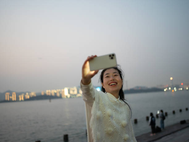 istock woman taking selfie by the beach at night 1473903245